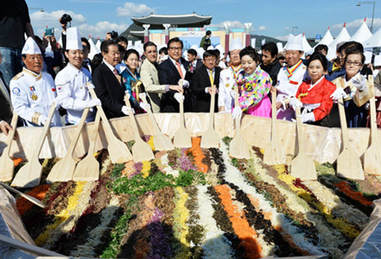 Park Jin, fifth from left, president of the Asia Future Institute, poses with Peter Tan, sixth from left, the Singapore ambassador to Korea in a “bibimbap” mixing event held at Gwanghwamun Square, Wednesday. They are joined by Park Mi-young, fourth from right, promotional ambassador for Korean Food; James Person, fifth from left, a researcher at the U.S. Wilson Center; Kim Chae-yeon, fourth from left, Hansik promotional ambassador; and Kim Choong-yong, third from left, former councilor of Jongno-gu, Seoul.  /  Korea Times photo by Shim Hyun-chul