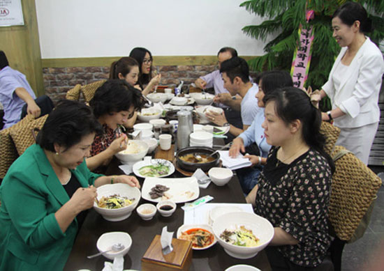 Lee Ae-ran, standing, watches a group of people enjoying North Korean food in Neungna Bapsang in Jongno, Seoul. / Courtesy of Neungna Bapsang