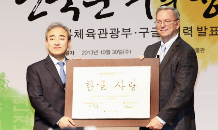 Google Executive Chairman Eric Schmidt, right, poses with Culture, Sports and Tourism Minister Yoo Jin-ryong after the Internet giant signed an agreement with the government, Wednesday, to help the country promote “hangeul,” the Korean alphabet. / Yonhap