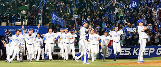The Samsung Lions rush the field after pitcher Oh Seung-hwan recorded the final out against the Doosan Bears in Game Seven of the Korean Series at Daegu Stadium, Friday. The Lions won 7-3, capturing their third title in as many years. / Yonhap