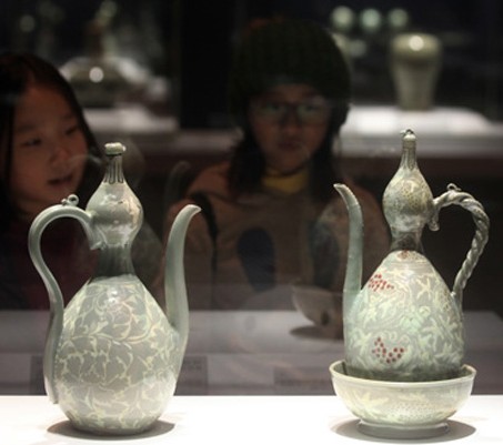 Visitors look at artifacts displayed at the National Museum of Korea’s Goryeo celadon exhibition hall, which reopened on Tuesday after a year of renovations. / Yonhap