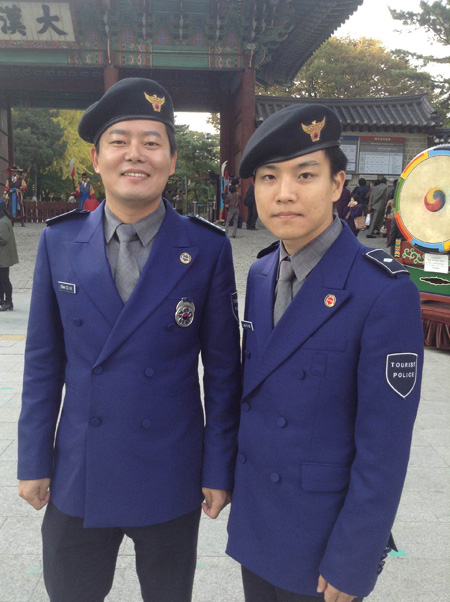 Sgt. Shin Chang-hoon, left, a tourist police officer, poses with his colleague Lee Kyung-min in front of Deoksu Palace while patrolling the area last month. / Korea Times photo by Kwon Ji-youn