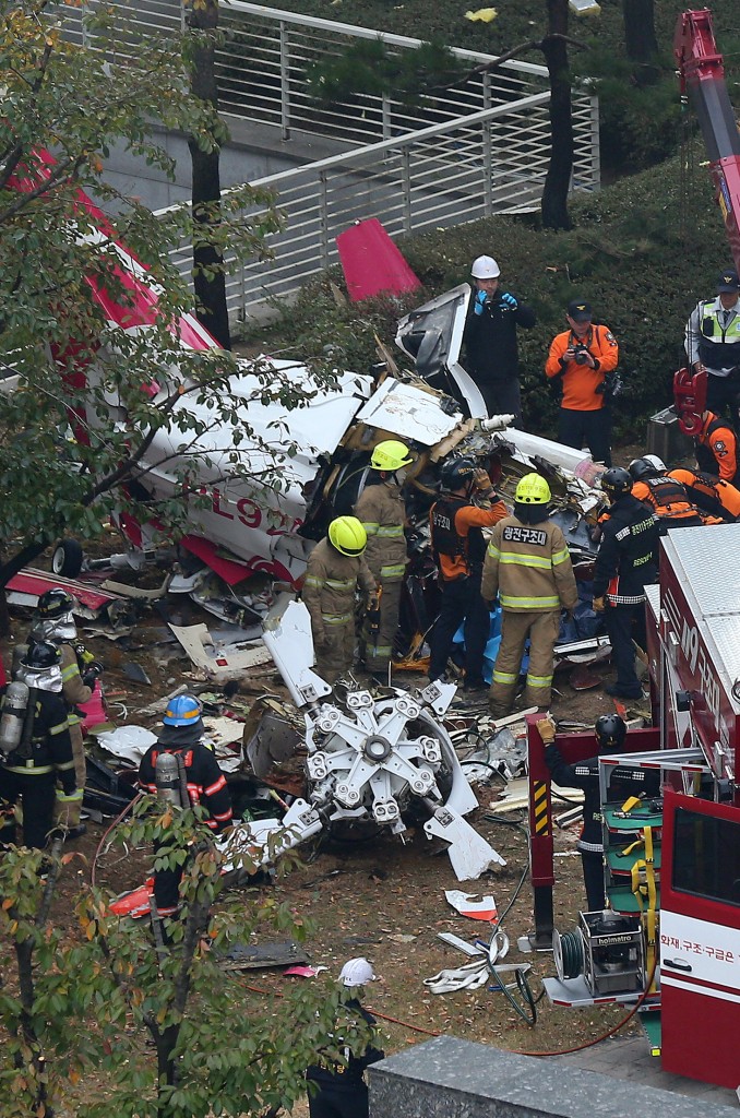 The firefighters on Saturday investigate the wreckages a site where a helicopter fell down after crashing into an apartment building in Samsung-dong, Seoul. (Yonhap News) 