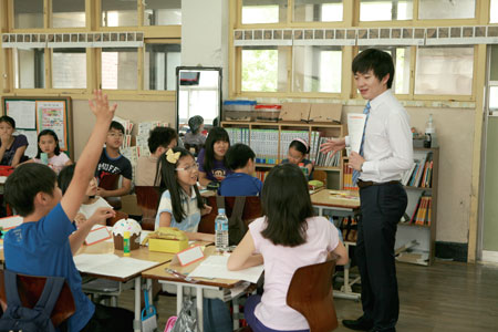 A certified public accountant of Samil PricewaterhouseCoopers teaches market economy for one day to elementary school students in Seoul on May 23, 2013.