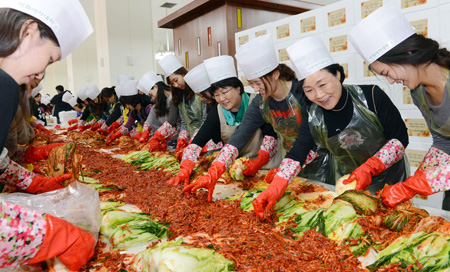 Students and graduates of Ewha Womans University make kimchi in this file phto taken in November last year at the school campus in northern Seoul.