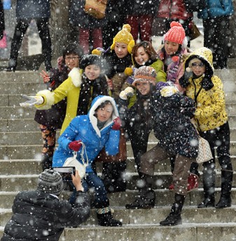 Foreign travelers enjoy the Hanok Village in Mt. Nam, Seoul, on a snowy day earlier this month. (Korea Times photo by Shim Hyun-chul)