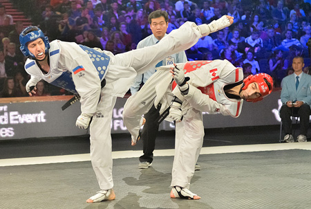 Russia’s Alexey Denisenko, left, and Canada’s Maxime Potvin exchange kicks during the men’s under-68-kilogram final match on the third and last day of the inaugural WTF World Taekwondo Grand Prix at the Manchester Central Convention Complex in Manchester, the United Kingdom, Monday (KST). Denisenko won to earn his country the gold medal. With no medals added on Monday, Korea finished a surprising sixth among 59 nations, without producing a single gold medalist. / Courtesy of WTF
