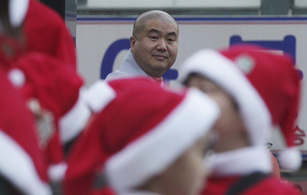 A Buddhist monk looks at Buddhist children wearing Santa Claus costumes as they prepare to attend a ceremony ahead of Christmas at the Chogye temple in Seoul. (AP Photo/Ahn Young-joon) 