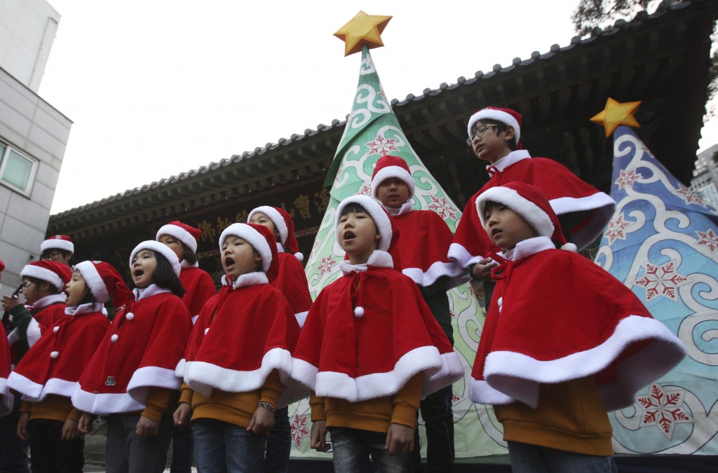 Buddhist children wearing Santa Claus costumes sing Christmas songs in a ceremony to celebrate upcoming Christmas at the Chogye temple in Seoul, South Korea, Wednesday, Dec. 18, 2013. South Korean Buddhists have been celebrating Christmas to show their goodwill toward Christians.(AP Photo/Ahn Young-joon)