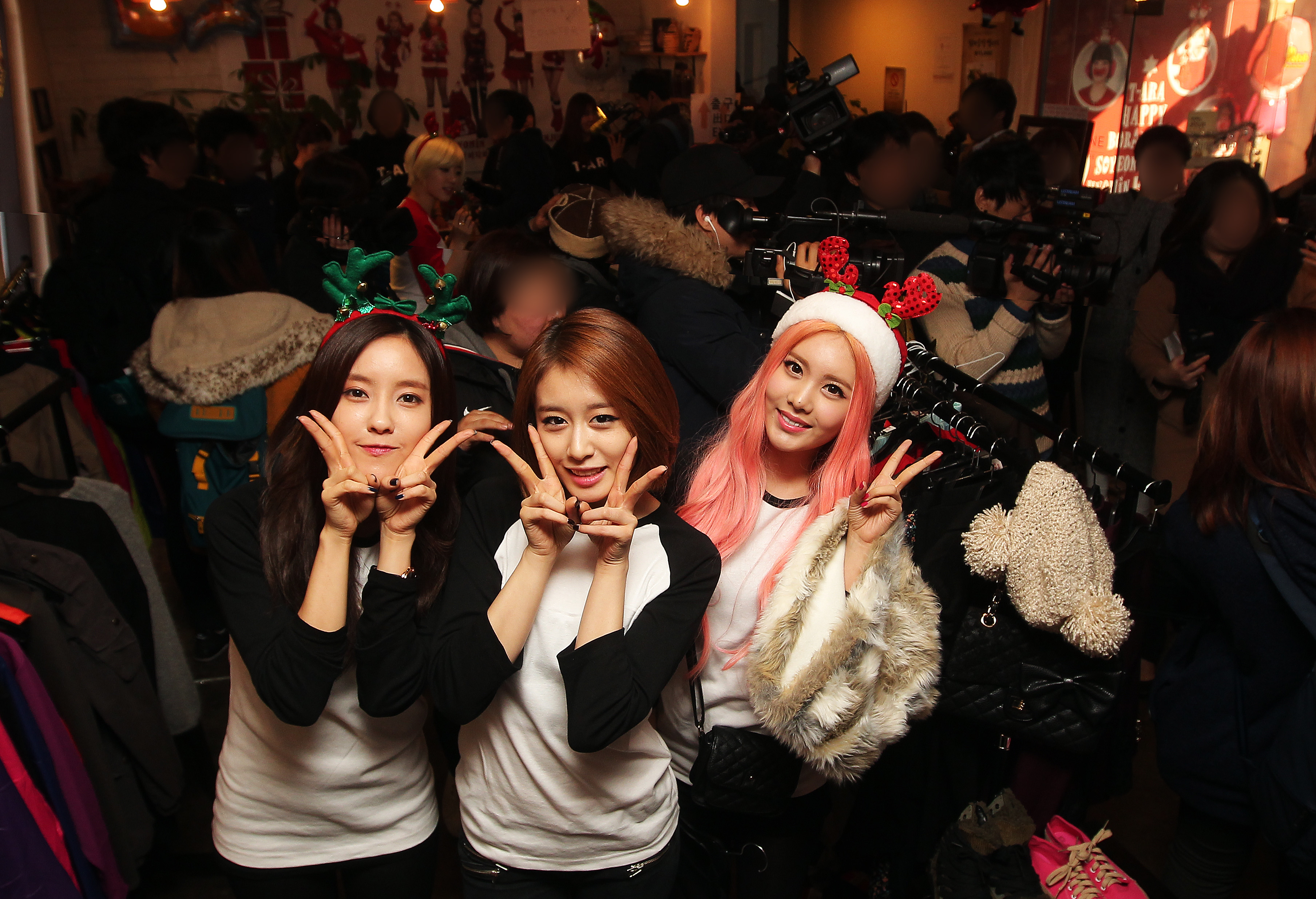 T-ara's Hyomin (from left), Ji-yeon, and Qri showed up at one Gangnam cafe
on Christmas Eve to help out with charity sale event. (Yonhap)