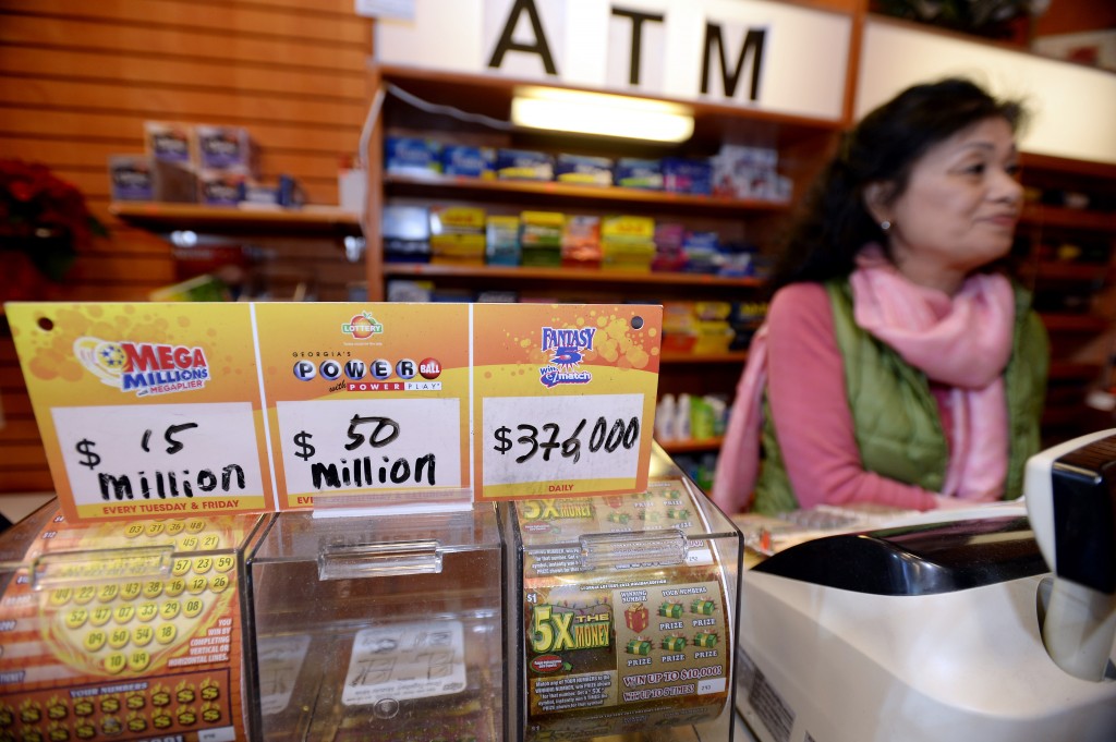 Owner Young Soolee tends the counter at her small Alliance Center office bulding newsstand on Wednesday, Dec. 18, 2013, in Atlanta, after lottery officials said one of two winning Mega Millions lottery tickets were purchased from her store in Tuesday's $636 million drawing, The store owner said she sold 1300 lottery tickets on Tuesday rather than the normal sales of about 100 tickets. (AP Photo/David Tulis)