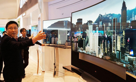 LG Display CEO Han Sang-beom checks out details of its massive 105-inch curved LCD TV at the firm’s booth at the Bellagio Hotel on the Las Vegas strip, Monday (KST). (Courtesy of LG Display)