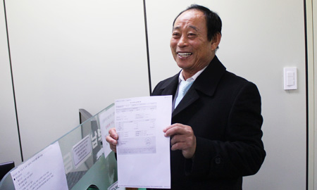 Kim Seong-do, 74, holds a receipt for the value-added tax the Dokdo resident paid for what he earned from the sale of Dokdo-related souvenirs last year, at the National Tax Service, Monday. (Courtesy of NTS)