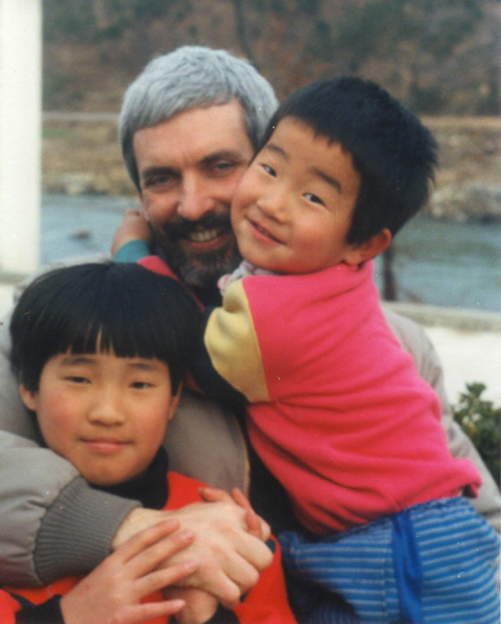 Father Luis Maria Uribe, center, smiles with children in this file photo.