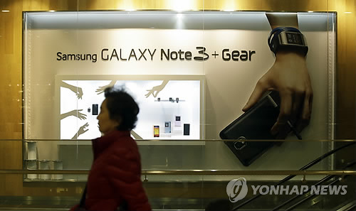 A woman walks by a billboard for Samsung Electronics' Galaxy Note 3 at a showroom of Samsung Electronics in Seoul, South Korea, Tuesday, Jan. 7, 2014. (Yonhap)