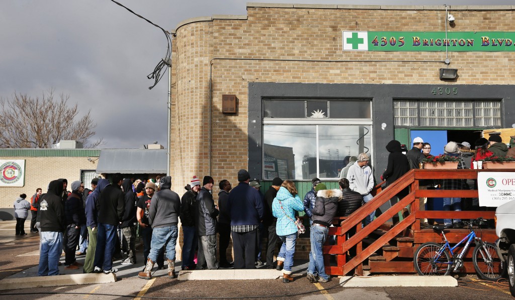 Customers stand in line shortly after the opening of 3D Cannabis Center, which opened as a legal recreational retail outlet in Denver at 8am on Wednesday Jan. 1, 2014. Colorado began retail marijuana sales on Jan. 1, a day some are calling "Green Wednesday." (AP Photo/Brennan Linsley)