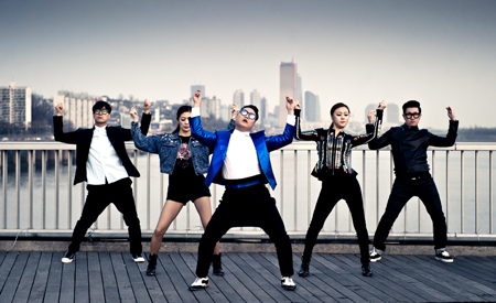 Lee Ju-sun, far left, dances with Psy in this photo captured from the singer’s “Gentleman” music video. The creator of the “Gangnam Style” horse-riding dance said many choreographers in Korea are wrestling economic trouble.