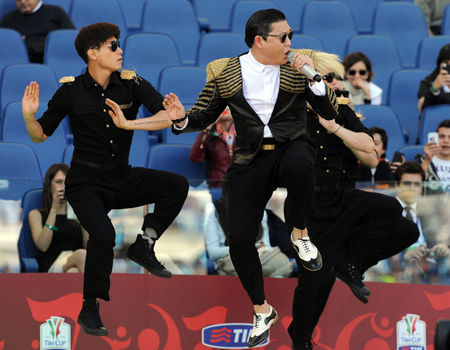 Lee Ju-sun, left, dances to “Gangnam Style” with Psy during intermission at the TIM Cup final match between AS Roma Vs. SS Lazio at Stadio Olimpico soccer arena in Rome, Italy, in this May 26, 2013 file photo.