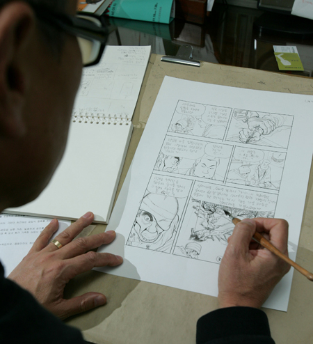 Cartoonist Huh Young-man is busy at work in his studio in Seoul in this Nov, 2007 photo. Huh represents the older generation of Korean cartoonists who used to thrive in print publishing. (Korea Times file)