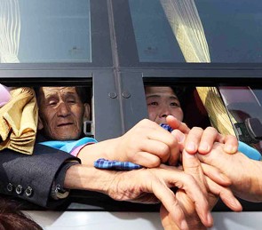 Family members attempt to hold on to each others’ hands as North Koreans board the bus to part from their South Korean relatives after holding their final reunions at Mt. Geumgang in North Korea’s east coast.
(Yonhap)