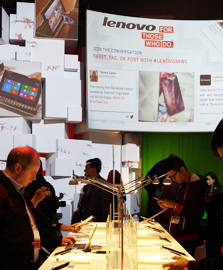 People test new 4G mobile devices in the booth of Lenovo Group, a Beijing-based technology company, during the Mobile World Congress (MWC) in Barcelona, Thursday.