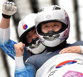 Two-man bobsleigh team pilot Won Yun-jong, left, and brakeman Seo Young-woo react as they cross the finish line in their final run at the Sochi Olympics at the Sanki Sliding Center, Monday. The team finished 18th overall, the highest ever for Korean bobsledders. (AP-Yonhap)