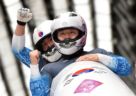 Two-man bobsleigh team pilot Won Yun-jong, left, and brakeman Seo Young-woo react as they cross the finish line in their final run at the Sochi Olympics at the Sanki Sliding Center, Monday. The team finished 18th overall, the highest ever for Korean bobsledders. (AP-Yonhap)