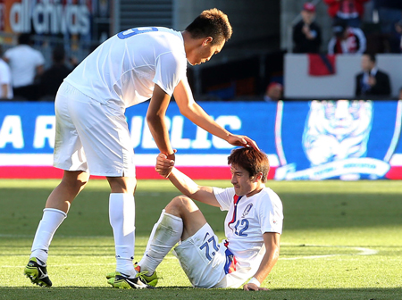 Forward Kim Shin-wook helps up midfielder Park Jong-woo during the Korean national team’s 2-0 loss to the United States in Carson, Calif., Sunday (KST). (Yonhap)