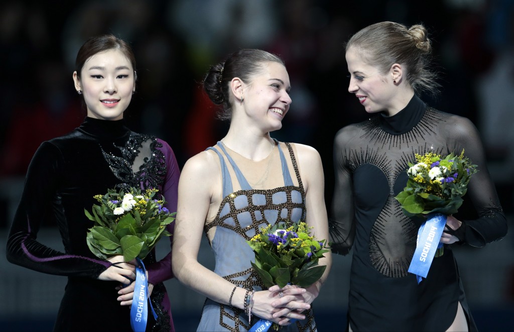 Adelina Sotnikova of Russia, centre, Kim Yuna of South Korea, left, and Carolina Kostner of Italy stand on the podium during the flower ceremony for the women's free skate figure skating final at the Iceberg Skating Palace during the 2014 Winter Olympics, Thursday, Feb. 20, 2014, in Sochi, Russia. Sotnikova placed first, followed by Kim and Kostner. (AP Photo/Ivan Sekretarev)