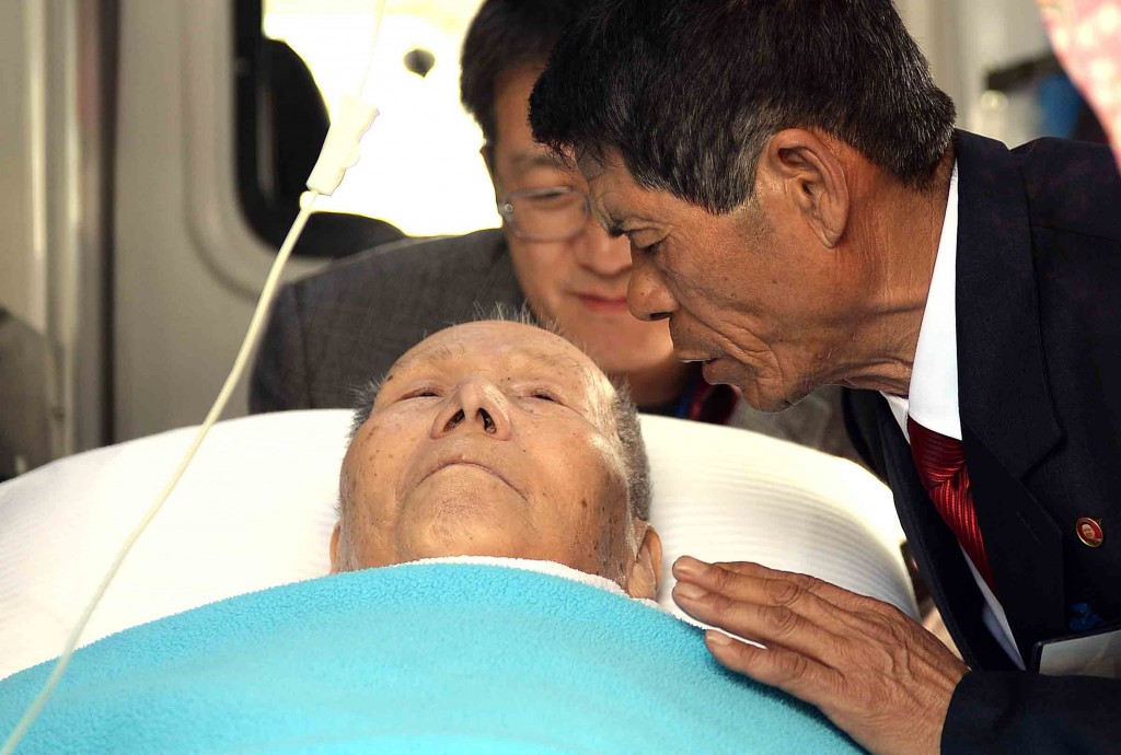 Kim Jin-chun, 66, says goodbye to his 91-year-old father Kim Sum-kyung from the South, in an ambulance parked in front of a hotel in Mt. Geumgang Resort in North Korea, Friday. The father had to return to the South a day before the official closing of the reunions of separated families during the Korea War, due to health problems.  (Yonhap)