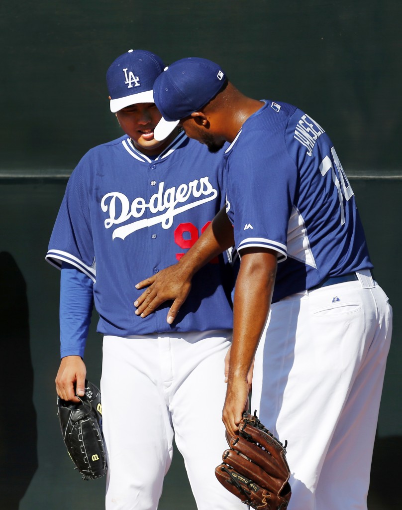 Los Angeles Dodgers' Kenley Jansen, right, notices much lighter Ryu Hyun-Jin, of South Korea, during spring training baseball practice Sunday, Feb. 9, 2014, in Glendale, Ariz. (AP Photo/Paul Sancya)