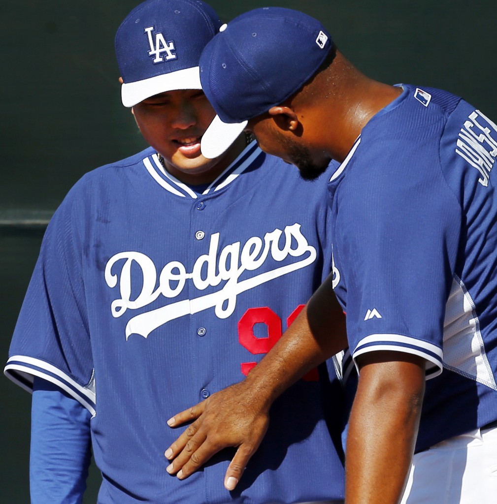 Los Angeles Dodgers' Kenley Jansen, right, notices much lighter Ryu Hyun-Jin, of South Korea, during spring training baseball practice Sunday, Feb. 9, 2014, in Glendale, Ariz. (AP Photo/Paul Sancya)