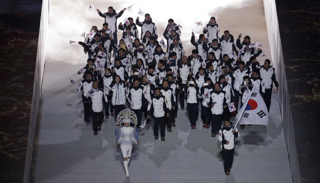 Lee Kyou-Hyuk of South Korea holds his national flag and enters the arena with teammates during the opening ceremony of the 2014 Winter Olympics in Sochi, Russia, Friday, Feb. 7, 2014. (AP Photo/Charlie Riedel)
