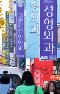 People walk down a street lined with cosmetic surgery clinics in Apgujeong-dong in Seoul. The clinics shown in the photo are not related to this article. (Korea Times file)