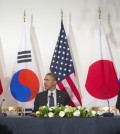 President Barack Obama watches as South Korean President Park Geun-hye, left, and Japanese Prime Minister Shinzo Abe, leave their seats at the opposite ends of the table, Tuesday, March 25, 2014, during the start of their trilateral meeting at the US Ambassador's Residence in the Hague, Netherlands. (AP Photo/Pablo Martinez Monsivais)