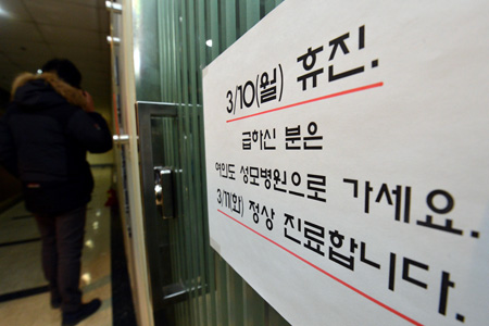 A notice giving details of a shutdown is posted on the door of a hospital in Seoul, Sunday, a day before doctors are scheduled to participate in a one-day strike. /  Korea Times photo by Kim Joo-sung