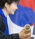 South Korean President Park Geun-hye holds the honorary doctorate document she received during a ceremony at the Dresden University of Technology in Dresden, Germany, Friday, March 28, 2014. (AP Photo/Jens Meyer)