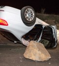 A car sits overturned on a highway in the Carbon Canyon area of Brea, Calif., Friday night, March 28, 2014, after hitting a rock slide caused by an earthquake. The people inside the car sustained minor injuries. A magnitude-5.1 earthquake centered in the area near Los Angeles caused no major damage but jittered nerves throughout the region as dozens of aftershocks struck into the night. (AP Photo/Kevin Warn)