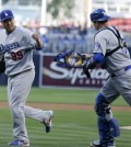 Dodgers starting pitcher Ryu Hyun-Jin, left, celebrates with catcher A.J. Ellis after getting the last out on the San Diego Padres  during the first inning of an opening night baseball game Sunday, March 30, 2014, in San Diego. (AP Photo/Gregory Bull)