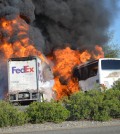 Massive flames engulf a tractor-trailer and a tour bus just after they collide on Interstate 5, Thursday, April, 10, 2014, near Orland, Calif. At least 10 people were killed in the crash, authorities said. (AP Photo/Jeremy Lockett)