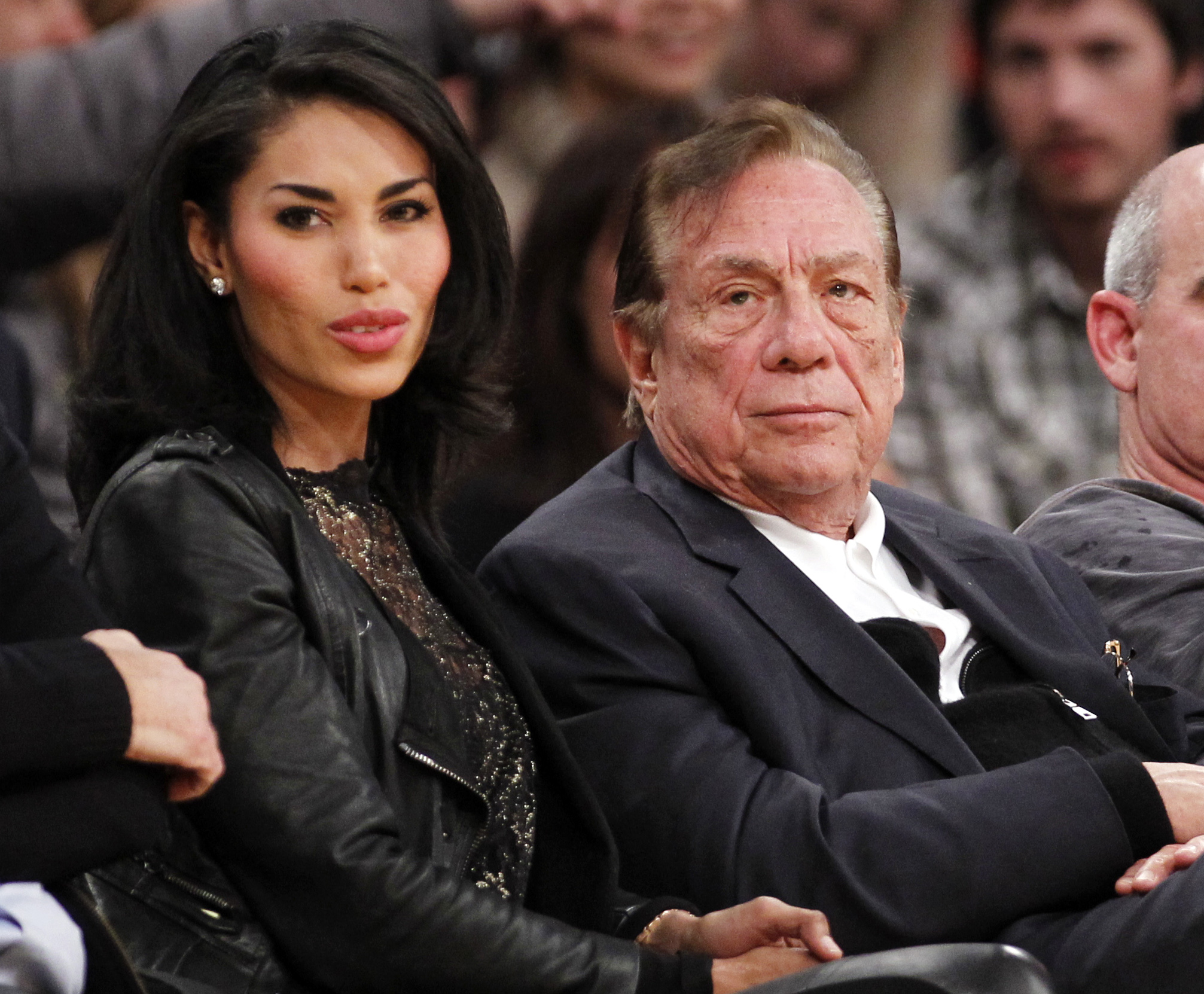 FILE - In this Dec. 19, 2010, file photo, Los Angeles Clippers owner Donald Sterling, third right, sits with V. Stiviano, left, as  they watch the Clippers play the Los Angeles Lakers during an NBA preseason basketball game in Los Angeles. NBA commissioner Adam Silver announced Tuesday, April 29, 2014, that he is banning the owner for life from the Clippers organization over racist comments in recording. (AP Photo/Danny Moloshok, File)