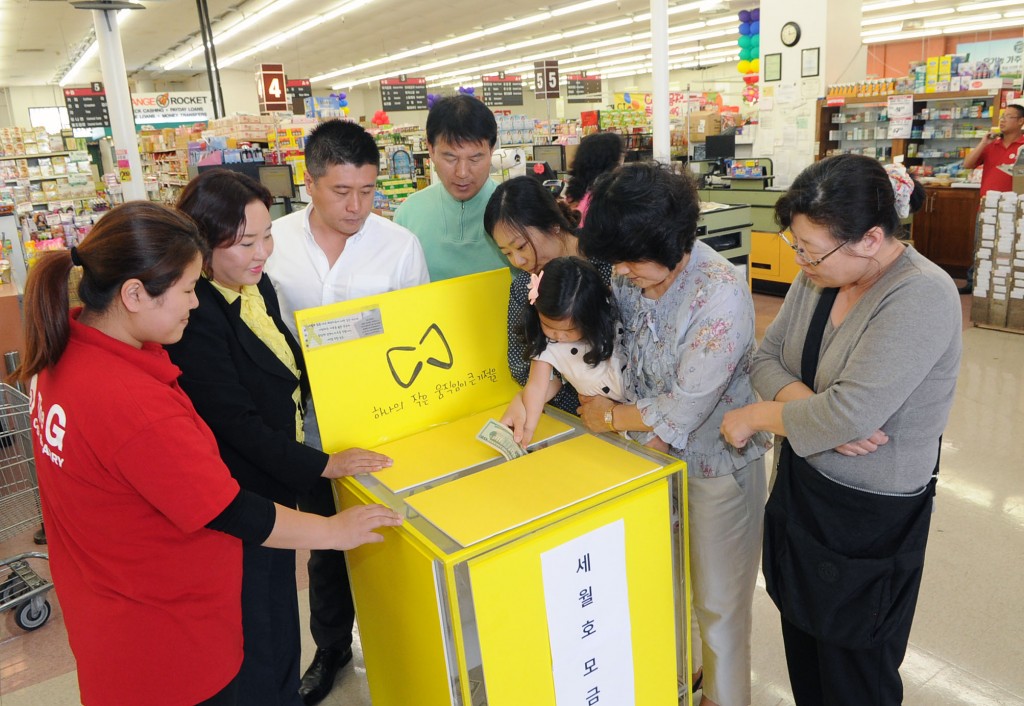 A child puts money into the donation box set up at Kaju Market. / Park Sang-hyuk, The Korea Times