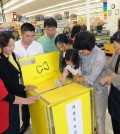 A child puts money into the donation box set up at Kaju Market. / Park Sang-hyuk, The Korea Times