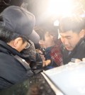 Lee Joon-seok, middle, the captain of the ferry Sewol that capsized off the southwest coast on Wednesday morning, went under questioning at the Mokpo Coast Guard Station in South Jeolla Province, Thursday. Lee, who was among the first to be rescued, said he was not sure about the cause of the sinking. (Yonhap)