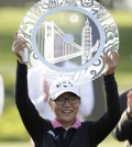 Lydia Ko of New Zealand holds up her trophy on the 18th green of the Lake Merced Golf Club after winning the Swinging Skirts LPGA Classic golf tournament on Sunday, April 27, 2014, in Daly City, Calif. Ko won the event after shooting a 3-under-par 69 to finish at 12-under-par. (AP Photo/Eric Risberg)