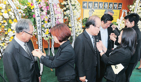 Korean American community leaders put on black ribbons at the memorial service set up inside the Korean American Federation of L.A. Center Thursday. / Park Sang-hyuk, The Korea Times