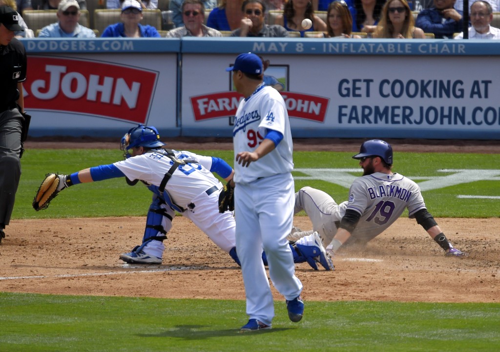 Colorado Rockies' Charlie Blackmon, right, scores after Brandon Barnes is caught stealing second as the ball goes past Los Angeles Dodgers catcher Tim Federowicz, left, while starting pitcher Ryu Hyun-Jin, of South Korea, looks on during the fifth inning of a baseball game, Sunday, April 27, 2014, in Los Angeles. (AP Photo/Mark J. Terrill)