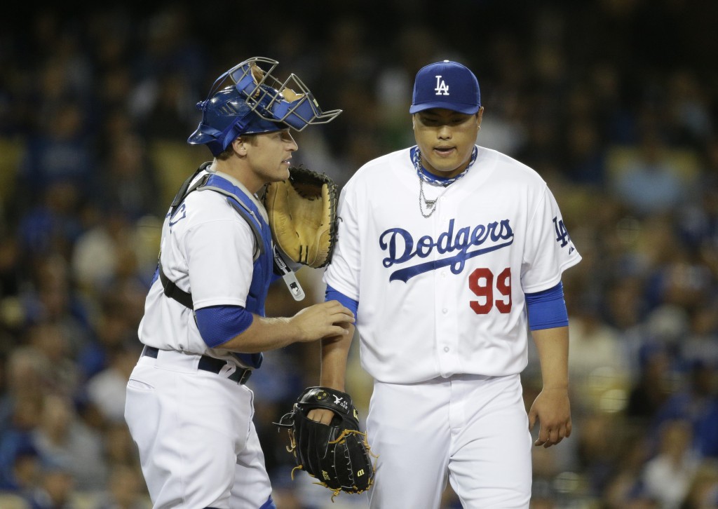 Los Angeles Dodgers catcher Tim Federowicz, left, talks to starting pitcher Hyun-Jin Ryu, of South Korea, during the fifth inning of a baseball game against the Philadelphia Phillies on Tuesday, April 22, 2014, in Los Angeles. (AP Photo/Jae C. Hong)