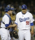Los Angeles Dodgers catcher Tim Federowicz, left, talks to starting pitcher Hyun-Jin Ryu, of South Korea, during the fifth inning of a baseball game against the Philadelphia Phillies on Tuesday, April 22, 2014, in Los Angeles. (AP Photo/Jae C. Hong)