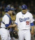 Los Angeles Dodgers catcher Tim Federowicz, left, talks to starting pitcher Hyun-Jin Ryu, of South Korea, during the fifth inning of a baseball game against the Philadelphia Phillies on Tuesday, April 22, 2014, in Los Angeles. (AP Photo/Jae C. Hong)